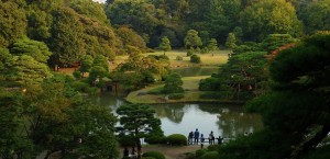 The panoramic view of the Rikugi-en Garden from the Fujishiro-toge hill vantage point. Green trees surround a serene lake. [15,16]